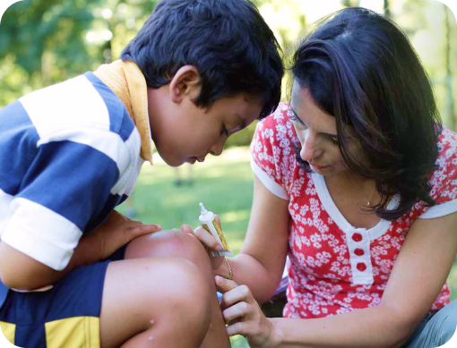 Mother treating her son’s cut with Neosporin antibiotic ointment.